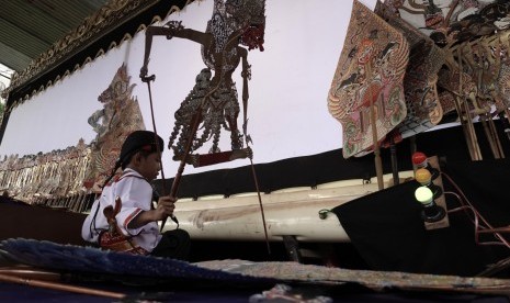 Faiq Maulana (8), mendalang wayang kulit dengan lakon Bima Suci, saat mengikuti lomba dalang cilik dalam Pesta Rakyat di Omah Tahu Purwokerto, Banyumas, Jateng, Kamis (26/12/2019). 