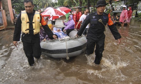 Anggota Kepolisian mengevakuasi warga terdampak banjir di Perumahaan Bukit Cengkeh II, Depok, Jawa Barat, Rabu (1/1).