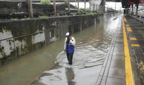 Petugas memeriksa rel kereta api yang terendam banjir di Stasiun KA Tanah Abang, Jakarta, Rabu (1/1/2020). 