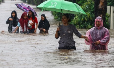 Warga melintasi banjir yang menggenangi Perumahan Pondok Maharta, Pondok Kacang, Tangerang Selatan, Banten, Kamis (1/1/2020). 