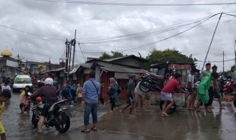 Sejumlah penyedia jasa ojek gerobak mengangkut motor maupun orang melewati genangan di Jalan Desa Semanan, Kelurahan Semanan Kecamatan Kalideres, Jakarta Barat, Kamis (2/1). 