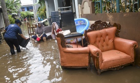 Warga membersihkan perabotan rumah dari endapan lumpur pascabanjir di Kawasan Cipinang Melayu, Jakarta, Kamis (2/1/2020). 