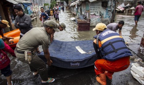 Anggota DPR Minta Pemerintah Antisipasi Penyakit Usai Banjir. Petugas berusaha mengangkat kasur yang terbawa banjir di kawasan Kampung Pedongkelan, Jakarta Timur, Kamis (2/1/2020). 