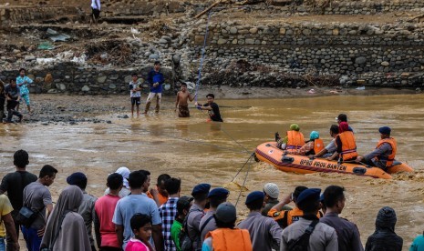 Sejumlah relawan membantu warga menyeberangi Sungai Ciberang untuk dievakuasi ke tempat aman di Kampung Susukan, Lebak, Banten, Kamis (2/1/2020). Sebanyak 28 jembatan di Kab Lebak rusak diterjang banjir bandang. 