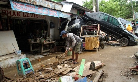 Warga membersihkan sisa lumpur pasca banjir yang merendam kawasan Pondok Gede Permai, Jatiasih, Bekasi, Jawa Barat, Kamis (2/1/2020).