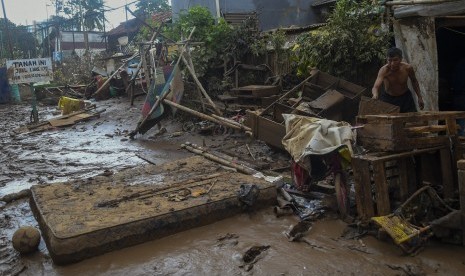  Warga membersihkan endapan lumpur sisa banjir di Rawajati, Jakarta, Kamis (2/1/2020).