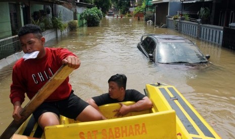 Relawan mendayung perahu untuk melakukan evakuasi warga yang terjebak banjir di dalam rumahnya di Perumahan Pondok Arum, Tangerang, Banten, Kamis (2/1/2019).