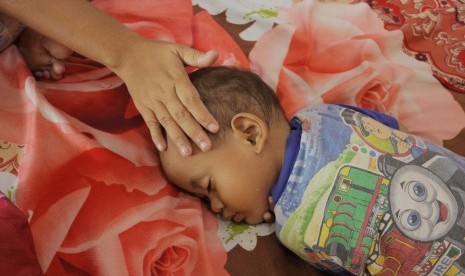 Para istri menteri mengunjungi dan menghibur anak-anak korban banjir. Foto seorang anak kecil korban banjir tertidur saat mengungsi, (ilustrasi).