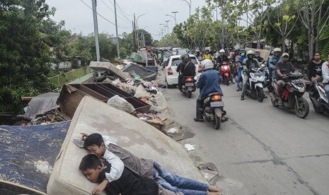 Sejumlah anak-anak bermain di tumpukan sampah perabotan rumah tangga pascabanjir di Duren jaya, Bekasi, Jawa Barat, Ahad (5/1/2020).