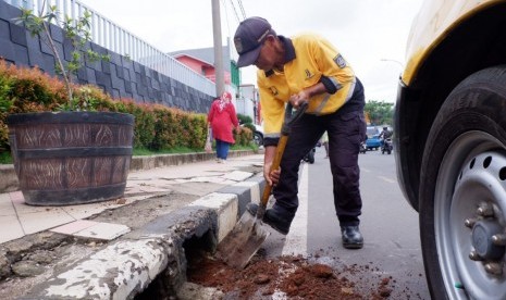 Cegah kembali terjadi banjir, Dinas Pekerjaan Umum dan Penataan Ruang (PUPR) Kota Depok melakukan pembersihan saluran air di sepanjang Jalan Margonda Raya, Kota Depok, Senin (6/1).