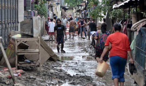 Sejumlah warga membersihkan lumpur pasca banjir yang menggenangi wilayah Jalan Mawar V RT. 008 RW 03, Kelurahan Margahayu, Bekasi Timur, Jawa Barat, Senin (6/1). Status tanggap daruta di Bekasi diperpanjang sepekan.