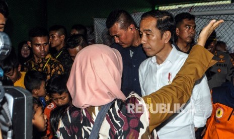 Presiden Joko Widodo (kanan kedua) berbincang dengan salah satu warga korban bencana di Desa Banjar Irigasi, Lebak, Banten, Selasa (7/1/2020).