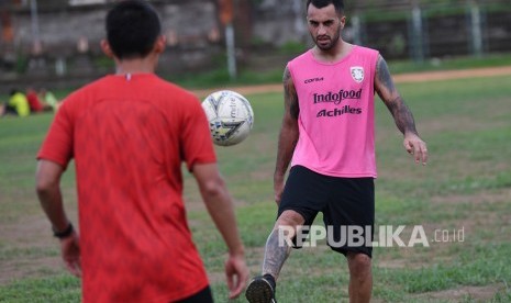 Pesepak bola Bali United Brwa Nouri (kanan) menendang bola ke rekannya Dias Angga Putra saat latihan ketahanan fisik di GOR Ngurah Rai, Denpasar, Bali.