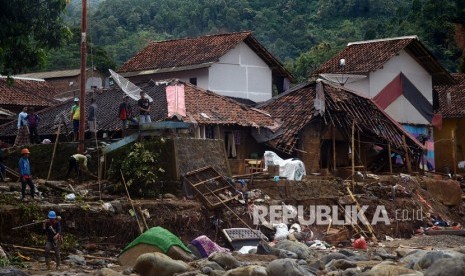 Sejumlah warga beraktivitas di dekat puing reruntuhan rumah yang rusak terkena banjir bandang (ilustrasi)