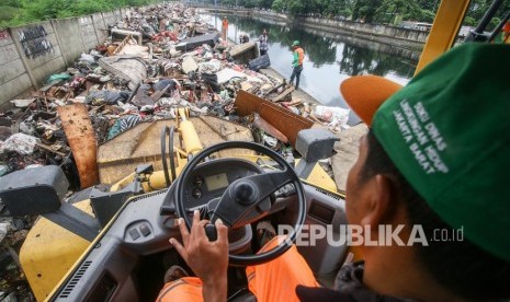 Pascabanjir, 21 Truk Angkut Sampah di Rawa Buaya. Foto: Petugas mengoperasikan alat berat untuk memindahkan sampah sisa banjir di Jalan Inspeksi Cengkareng Grand, Daan Mogot, Jakarta, Kamis (9/1/2020). 