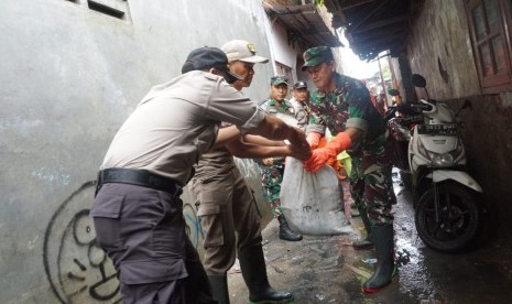 Petugas gabungan dari Polri, TNI dan Kecamatan Kalideres atau yang sering disebut tiga pilar kompakan membersihkan sampah dan lumpur sisa banjir. Sampah dan lumpur yang tiga pilar bersihkan itu di RW 01 Kelurahan Semanan, Jakarta Barat. 