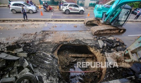 Petugas melakukan proses perbaikan jalan yang amblas di Jalan Daan Mogot, Kota Tangerang, Banten, Ahad (12/1/2020).