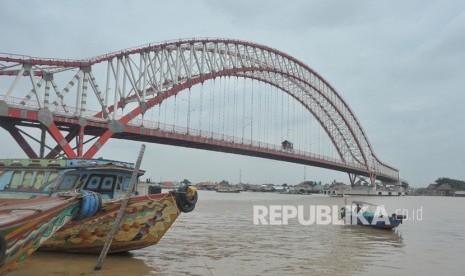 Kapal kayu melintas di sekitar pembangunan Jembatan Musi VI (ilustrasi). Pembangunan jembatan yang dimulai pada 2015 itu diperkirakan rampung Desember 2020.