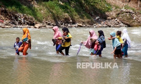 Sejumlah warga memaksakan diri untuk menyeberangi Sungai Cikaniki yang menghubungkan Desa Tonjong Rumpin dan Desa Kantalarang Leuwiliang di Rumpin, Kabupaten Bogor. (Ilustrasi)