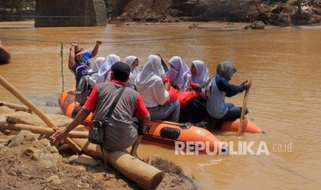 Jembatan Hanyut, Warga Lebak Menyeberang Pakai Perahu Karet. Sejumlah relawan membantu anak sekolah menyeberangi Sungai Ciberang dengan perahu karet di Sajira, Lebak, Banten.