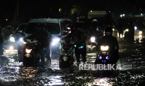 Pengendara kendaraan bermotor melintas di jalan yang tergenang air di Jalan Dr Soetomo, Surabaya, Jawa Timur, Rabu (15/1/2020). 