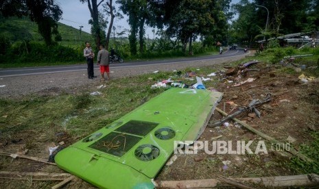 Seorang warga bersama petugas kepolisian mengamati lokasi kejadian kecelakaan tunggal bus P.O Purnamasari di Nagrog, Ciater, Kabupaten Subang, Jawa Barat, Ahad (19/1/2020).