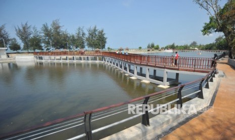 Pariaman Targetkan Empat Juta Wisatawan 2020. Pengunjung melintas di jembatan objek wisata Talao Pauh, di Pariaman, Sumatra Barat.