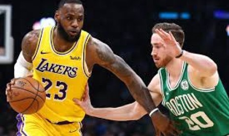 Bintang Los Angeles Lakers LeBron James membawa bola saat berhadapan dengan Boston Celtics dalam kompetisi basket NBA.