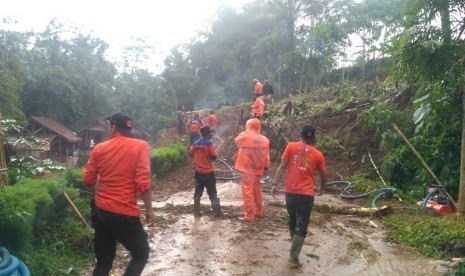 Petugas membersihkan material longsoran yang menutup akses di Tasikmalaya (ilustrasi).