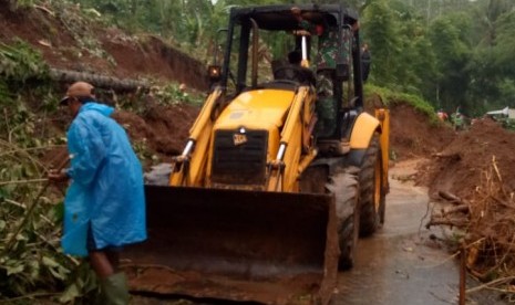 Petugas membersihkan material longsoran yang menutup akses Jalan Cikeusal-Warung Legok, tepatnya di Kepunduhan Sukalebar RT 29/6 Desa Pasirsalam, Kecamatan Mangunreja, Kabupaten Tasikmalaya, Rabu (22/1).