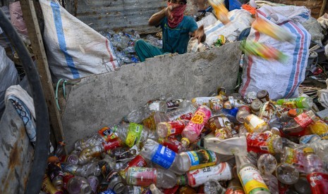 Seorang pemulung memilah sampah plastik yang dikumpulkannya untuk didaur ulang