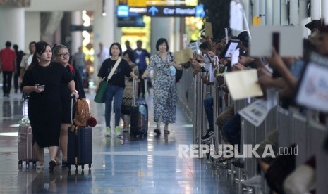 Sejumlah wisatawan membawa barang bawaan setibanya di Terminal Kedatangan Internasional Bandara Internasional I Gusti Ngurah Rai, Bali, Rabu (22/1/2020). Corona telah menyebabkan pembatalan kunjungan wisawatan China ke Bali.