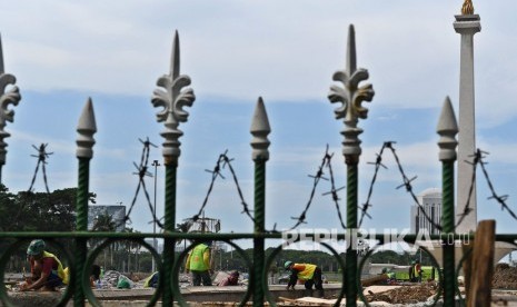 Sejumlah buruh mengerjakan pembangunan Plaza Selatan Monumen Nasional (Monas) di Jakarta, Rabu (22/1/2020). 