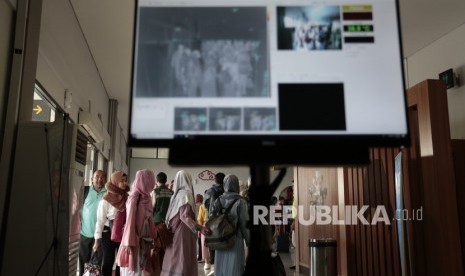 Petugas Kantor Kesehatan Pelabuhan Yogyakarta mengoperasikan alat deteksi suhu tubuh saat kedatangan penumpang dari Malaysia di Bandara Internasional Adisutjipto, Kamis (23/1/2020).