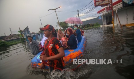 Warga melintasi banjir menggunakan perahu di Total Persada, Periuk, Kota Tangerang, Banten, Jumat (24/1/2020). 