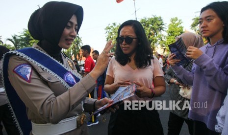 Polisi wanita melakukan sosialisasi  Electronic Traffic Law Enforcement (ETLE) atau e-tilang pada pengguna kendaraan bermotor.