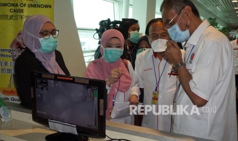 Menteri Kesehatan Malaysia Dzulkefly Ahmad (kanan) melihat peralatan thermal scanner untuk mendeteksi penumpang yang mengidap virus corona saat melakukan inspeksi ke Bandara Kuala Lumpur International Airport (KLIA) 2 di Sepang, Senin (27/01/2020).