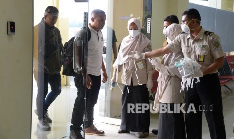 Penumpang Bandara Sultan Iskandar Muda Terus Berkurang. Petugas Kantor Kesehatan Pelabuhan (KKP) membagikan masker kepada penumpang pesawat yang datang dari luar negeri saat tiba di Bandara Internasional Sultan Iskandar Muda, Aceh Besar, Aceh.