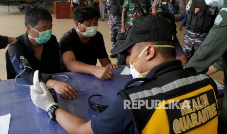 Petugas Karantina Kesehatan Pelabuhan (KKP) Kupang memeriksa kesehatan enam warga negara China yang terdampar di perairan Rote Ndao setibanya di Lantamal VII Kupang, NTT, Kamis (30/1/2020)