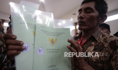 Warga menunjukkan sertifikatnya saat penyerahan sertifikat tanah (ilustrasi). Badan Pertanahan Nasional (BPN) Kabupaten Kediri, Jawa Timur, menyerahkan sebanyak 13.882 sertifikat tanah untuk masyarakat di Kabupaten Kediri, setelah proses pembuatan sertifikat selesai dibuat.