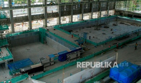 Pekerja menyelesaikan pembangunan venue Aquatic PON XX Papua. Komisi X DPR mendesak pemerintah menunda penyelenggaraan PON XX di Papua.