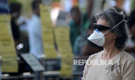 Seorang penumpang pesawat mengenakan masker di area Terminal Kedatangan Internasional Bandara Internasional I Gusti Ngurah Rai, Bali, Jumat (31/1/2020).