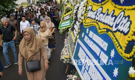 Sejumlah pelayat melintas di depan karangan bunga ucapan belasungkawa atas wafatnya KH Salahuddin Wahid atau Gus Sholah di rumah duka di kawasan Mampang Prapatan, Jakarta, Senin (3/2/2020).