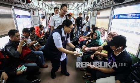 VP Corporate Communication PT KCI Anne Purba (tengah) membagikan masker kepada penumpang di Stasiun Tanah Abang, Jakarta.