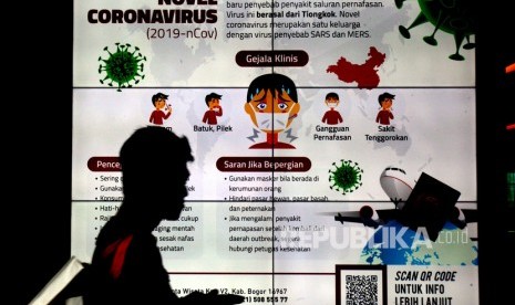 Warga melintas didepan videotron sosialisasi pencegahan virus corona. 