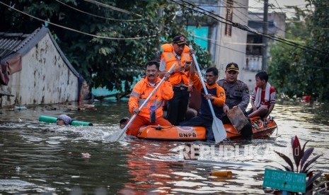 Petugas mengevakuasi warga terdampak banjir di Periuk Damai, Kota Tangerang, Banten, Senin (3/2/2020). 