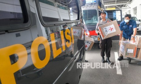 Personel Polisi mengangkat kardus yang berisi masker. Anggota Polres Boven Digoel memasok masker untuk anggotanya.