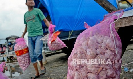 Pedagang membawa karung berisi bawang putih yang akan dijual di Pasar Minasa Maupa, Kabupaten Gowa, Sulawesi Selatan, Rabu (5/2/2020).