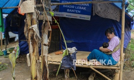 Seorang warga mengasuh anaknya di depan tenda pengungsian di Kampung Seupang, Lebak, Banten, Rabu (5/2/2020).