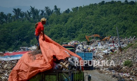 Petugas melakukan bongkar muat sampah di Tempat Pembuangan Akhir (TPA). 